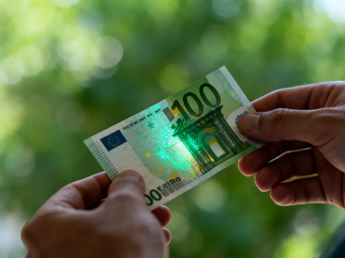Banknot euro przechylany w celu sprawdzenia hologramu i zmiany koloru